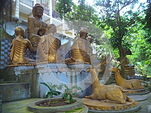 A Buddha statue giving advice to his followers accompanied by two deer