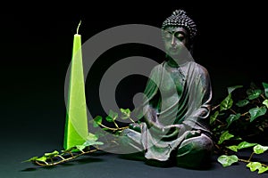 Buddha statue with green candle photo