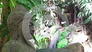 Buddha statue head against the background of falling water