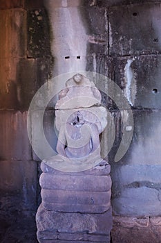 Buddha statue without a head. Ancient damaged sculpture in Angkor Wat