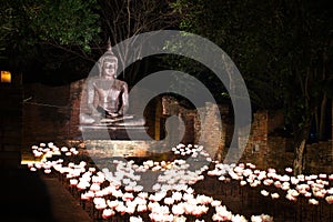 The Buddha Statue with Lighting lotus flower at Night. The style of Ayuthaya Era of Thailand