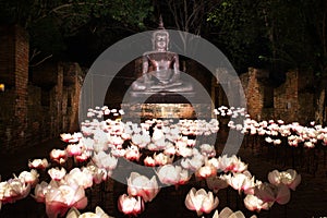 The Buddha Statue with Lighting lotus flower at Night. The style of Ayuthaya Era of Thailand