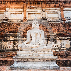 Buddha statue on old wall background in an ancient city in Thailand. Medieval Buddhist temple Wat Yai Chai Mongkhon in Ayutthaya