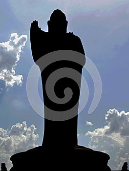Buddha statue silhouette with clouds