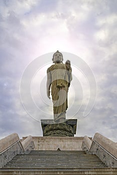 Buddha statue with a sky background and a flash of light over his head.