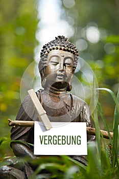 Buddha statue with the word Vergebung photo