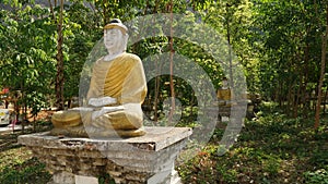 Buddha Statues in a green field at the base of Mount Zwegabin near Hpa-An, Myanmar.