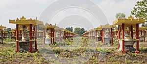 Buddha Statues in a green field at the base of Mount Zwegabin near Hpa-An, Myanmar.