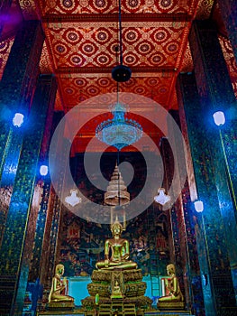 Buddha statues with mural painting around.