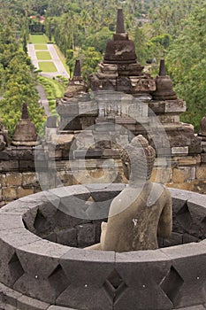 Buddha statues overlooking surroundings at Borobudur temple at sunrise in Java Indonesia