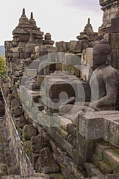 Buddha statues overlooking surroundings at Borobudur temple at sunrise in Java Indonesia