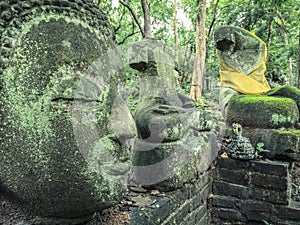 Buddha vestige in green nature at Wat Umong, Chiang Mai, Thailand, green buddha portrait covered with moss photo