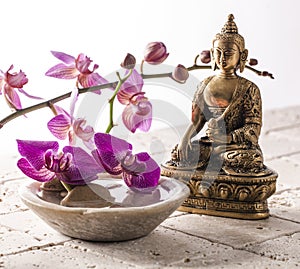 Buddha for zen attitude with stone and flowers