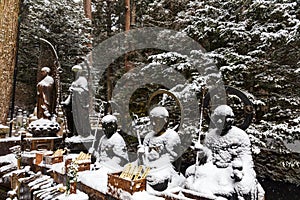 Buddhas under falling snow in Okunoin Cemetery, Koyasan area in the mount Koya, UNESCO World Heritage, Wakayama prefecture, Japan