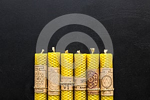 Buddhism. Candles with Yantras and mantras in sanskrit on black background top view pattern copy space