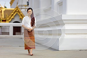 Buddhist asian woman is doing walking meditation around temple for peace and tranquil religion practice
