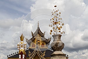 Buddhist background with amazing cloudy sky, buddhist statue, traditional temple and golden flower