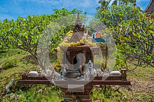 Buddhist beautiful wooden altar with candles and bowls in the park near temple. Thailand