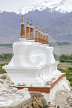 Buddhist chortens, white stupa and Himalayas mountains in the background near Shey Palace in Ladakh, India