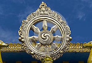 Buddhist Dharma wheel against blue sky