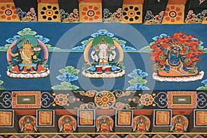Buddhist divinities and diverse patterns are painted on a wall of a temple (Bhutan)