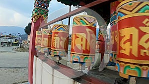 Buddhist monastery spinning prayer wheels close up at monastery from flat angle