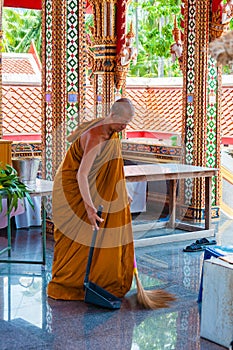 Buddhist monk doing some cleaning at buddhist temple from Damnoen Saduak Floating Market