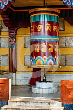 Buddhist monk rotating big prayer wheel