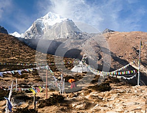 Buddhist monk, stupa and prayer flags near Pangboche