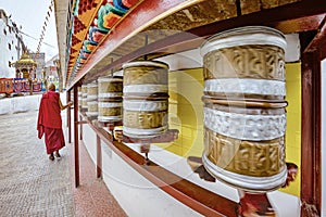 A buddhist monk tuning golden prayer wheels at the Soma Gompa in the Indiana Himalayas in Leh city.