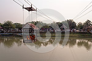 Buddhist Monks in a cable car crossing the Chao Phraya River