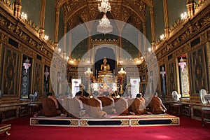 Buddhist monks are praying in the main hall of the Wat Ratchabophit, in Bangkok (Thailand) photo