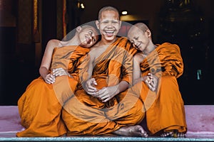 Buddhist novices sitting together feeling happy and smile