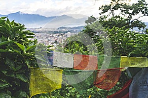 Buddhist prayer flags and the city view of Kathmandu, Nepal against the backdrop of mountains