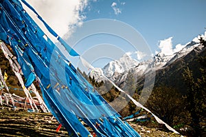 Buddhist prayer flags in front of snowy mountains in Higlands o China