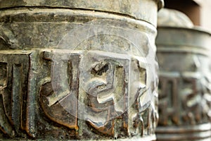 Buddhist prayer spinning drums with ancient mantras close up. Fixture for traditionhal Buddist prayer photo