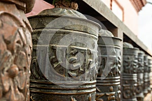 Buddhist prayer spinning drums with ancient mantras close up. Fixture for traditionhal Buddist prayer