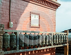 Buddhist prayer spinning drums with ancient mantras close up. Fixture for traditionhal Buddist prayer