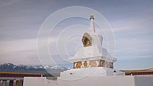 Buddhist prayer wheels drums in datsan. Woman tourist spinning a drums near the statue of the Buddha in Arshan. Buddhism