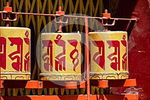Buddhist prayer wheels in Tibetan monastery with written mantra. India, Himalaya, Ladakh, Buddhist prayer drums with close-up mant