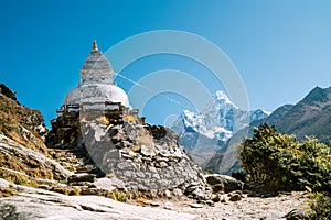 Buddhist Stupa - architectural and religious structure with Ama Dablam 6814m peak covered with snow and ice. Imja Khola valley in photo
