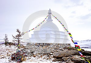 Buddhist stupa of enlightenment on the island Ogoy with flags. Baikal.