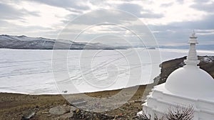 Buddhist stupa on the island of Ogoy on Baikal lake. Clip. Culture and traditions of Siberia, white stupa on frozen