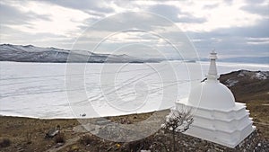 Buddhist stupa on the island of Ogoy on Baikal lake. Clip. Culture and traditions of Siberia, white stupa on frozen