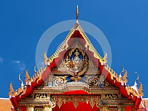 Buddhist temple gable soars into blue sky