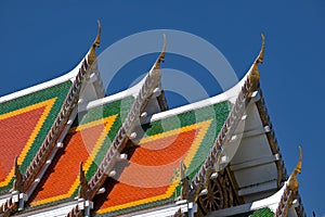 Buddhist temple`s roofs soar into blue sky