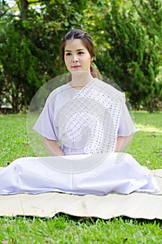 Buddhist thai woman happy with white clothing sitting for meditation