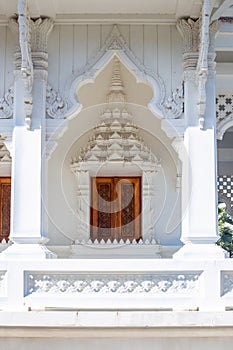 Buddhist white temple Wat Sawang Arom with convex stucco and wooden door photo