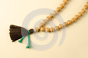 Buddhist wooden consecrated juniper rosary on beige background. A rosary of 108 beads