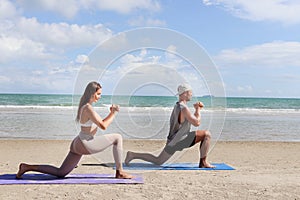 Buddy athlete woman, man doing yoga and stretching body on summer island beach, couple practicing yoga at seashore of tropical